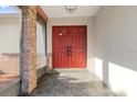 Welcoming front porch area features double red doors, brick accents, and tile flooring at 2233 Curlew Rd, Dunedin, FL 34698