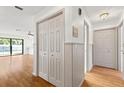 Hallway with hardwood floors, closet and trim, leads to pool view through sliding glass doors at 2233 Curlew Rd, Dunedin, FL 34698