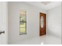Bright entryway featuring a beautiful wood door, neutral walls and white tile flooring at 2308 Long Green Ct, Valrico, FL 33596