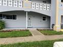 Unit exterior with a covered porch, lawn, and a well-kept garden bed at 2410 Franciscan Dr # 18, Clearwater, FL 33763