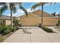 Charming front exterior of a residential home featuring a spacious two-car garage, and a well manicured lawn at 2427 Nottingham Greens Dr, Sun City Center, FL 33573