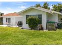 A backyard with a lawn and a patio featuring a table and chairs, and a grill for outdoor dining at 2436 Nuremberg Blvd, Punta Gorda, FL 33983