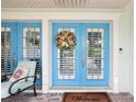 Inviting entrance with double doors, colorful wreath, and comfortable seating at 316 Cedar Ln, Largo, FL 33770