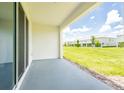 Sliding glass doors lead to a covered patio with views of the manicured backyard and neighborhood at 33063 Tulip Petal Ln, Wesley Chapel, FL 33545