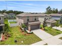 Aerial view of two-story home featuring a two-car garage and landscaped front yard at 36412 Garden Wall Way, Zephyrhills, FL 33541