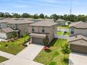 Aerial view of a two-story home featuring a two-car garage and landscaped front yard at 36412 Garden Wall Way, Zephyrhills, FL 33541