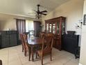 Elegant dining room featuring a classic wooden dining set, a large hutch, and neutral tile flooring at 4436 Horseshoe Pick Ln, Valrico, FL 33594