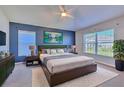 Serene bedroom featuring cool tones, a large bed, and plenty of natural light from the bright windows at 5046 Gato Del Sol Cir, Wesley Chapel, FL 33544