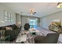 Bright living room featuring hardwood floors, stylish furniture, and a sliding glass door to the patio at 5046 Gato Del Sol Cir, Wesley Chapel, FL 33544