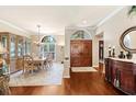 Elegant dining room featuring hardwood floors, a chandelier, and a wooden dining set, adjacent to the entry at 511 Duque Rd, Lutz, FL 33549