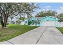 Charming turquoise home with a well-manicured lawn and a concrete driveway at 5283 Bevens Ave, Spring Hill, FL 34608