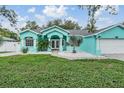 Charming turquoise home featuring decorative rock landscaping and a freshly manicured lawn at 5283 Bevens Ave, Spring Hill, FL 34608