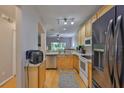 Functional kitchen featuring stainless steel appliances, light wood cabinets, and a view into the living area at 5717 Fishhawk Ridge Dr, Lithia, FL 33547