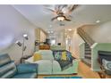 Open-concept living room with modern lighting, hardwood floors, and staircase access at 5717 Fishhawk Ridge Dr, Lithia, FL 33547