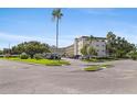 Condo complex with a manicured lawn, mature trees, and convenient parking at 5725 80Th N St # 301, St Petersburg, FL 33709
