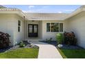 Elegant front entrance with modern double doors, complemented by tasteful landscaping and a stone pathway at 5884 51St S St, St Petersburg, FL 33715
