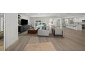 Bright and airy living room featuring hardwood floors and stylish furniture, flowing into the kitchen and pool area at 5884 51St S St, St Petersburg, FL 33715