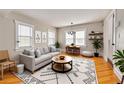 Bright living room with modern decor, wooden floors, and ample seating, perfect for relaxation and entertaining at 6408 N Central Ave, Tampa, FL 33604
