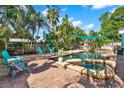 Backyard oasis featuring a large swimming pool, in-ground hot tub, brick patio, and lush tropical landscaping at 6844 34Th N Ave, St Petersburg, FL 33710