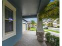 Inviting front porch with brick flooring and stone support columns, offering a welcoming entrance at 9816 Ivory Dr, Sun City Center, FL 33573