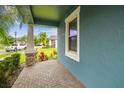 Charming front porch featuring brick flooring, stone support columns and a view of the street at 9816 Ivory Dr, Sun City Center, FL 33573