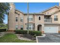 Home exterior showcasing attached garage, bay window, and quaint balcony, surrounded by neatly trimmed bushes and green space at 10436 Villa View Cir, Tampa, FL 33647