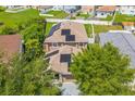 This aerial shot displays a home with solar panels on the roof, a manicured yard, and a view of the neighborhood at 11130 Summer Star Dr, Riverview, FL 33579