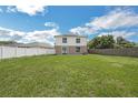 Expansive backyard with a well-maintained lawn, and white and wooden fences at 11130 Summer Star Dr, Riverview, FL 33579