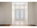 Inviting foyer with tile flooring, a decorative door, and high ceilings at 11412 Alden Ct, Hudson, FL 34667