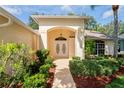 Close-up of the front entrance with lush landscaping and charming double doors at 11412 Alden Ct, Hudson, FL 34667