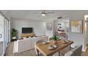 Open-concept living area with modern furniture, dining table and view into the kitchen at 1207 Chevy Chase Dr, Sun City Center, FL 33573