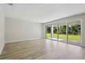 Open living room with hardwood floors and sliding glass doors to the backyard at 12758 Oak Hill Way, Parrish, FL 34219