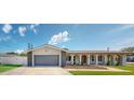 Charming one-story home featuring a gray two-car garage and an arched walkway to the front door at 140 88Th Ne Ave, St Petersburg, FL 33702
