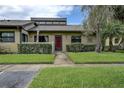 Inviting front of home with well-manicured lawn, mature landscaping, and shaded walkway at 140 Dale Pl, Oldsmar, FL 34677