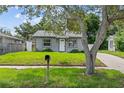 Quaint home with a green lawn and mature tree, enhancing curb appeal at 1743 Fulton Ave, Clearwater, FL 33755