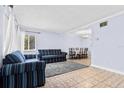 Inviting living room features neutral tile flooring and a comfortable seating arrangement with large windows at 1813 Bough Ave # B, Clearwater, FL 33760
