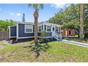 Charming exterior featuring a dark gray home with white trim, complemented by a green lawn and tropical foliage at 2026 Union S St, St Petersburg, FL 33712