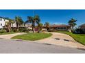 Charming single-story home featuring a spacious driveway and beautiful landscaping with mature palm trees at 208 Bath Club N Blvd, North Redington Beach, FL 33708