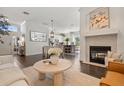 Elegant living room with fireplace, modern furniture, and an open floor plan leading to the dining and kitchen area at 2182 Trevor Rd, Palm Harbor, FL 34683