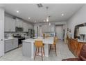 Modern kitchen with island, stainless appliances, gray cabinets, and decorative backsplash at 2507 Arbor Wind Dr, Lutz, FL 33558