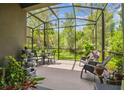 Relaxing screened patio with outdoor seating and views of the lush backyard at 28568 Tranquil Lake Cir, Wesley Chapel, FL 33543