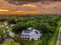 The sun sets on this property with its metal roof and solar panels sitting on an oversized lot surrounded by lush landscaping at 321 Barbara Cir, Belleair, FL 33756