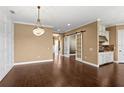 Dining room features dark wood floors and decorative chandelier, with adjacent white kitchen cabinets at 3214 Forsythia Dr, Odessa, FL 33556