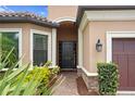 Elegant front entry with a black door framed by manicured landscaping and a brick walkway at 3214 Forsythia Dr, Odessa, FL 33556