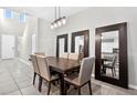 Bright dining area with a modern light fixture and large mirrors at 33854 Floating Heart Ct, Wesley Chapel, FL 33545