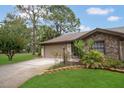 Charming home featuring a stone facade, well-maintained lawn, and inviting landscaping at 3902 Shoreside Cir, Tampa, FL 33624