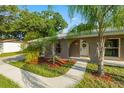 The welcoming front entrance features a white door with decorative wreath and a neatly landscaped garden bed at 4307 Foxglen Ln, Tampa, FL 33624