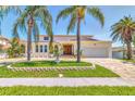Charming single-Gathering home showcasing a manicured front yard, brick driveway, and traditional architecture at 451 Palm Ne Is, Clearwater Beach, FL 33767
