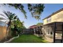 Expansive backyard with lush green lawn, privacy fence, and screened-in porch, perfect for outdoor living at 5110 Corvette Dr, Tampa, FL 33624