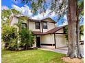 Inviting two-story home with a well-kept lawn, lush landscaping, and attached two-car garage at 5110 Corvette Dr, Tampa, FL 33624